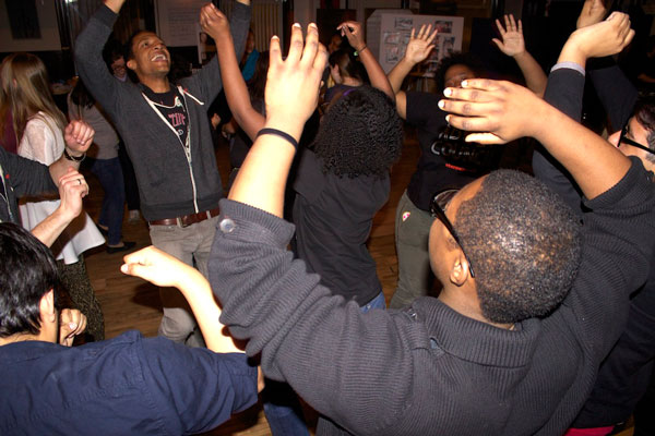 Jerry MacKinnon (Chuck from <em>Leveling Up</em>) throws is hands up with a group of enthusiastic teens.