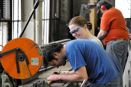 Marcos Everstijn, scenic carpentry apprentice Ariel Lauryn and Adam Ashlock measuring and cutting steel