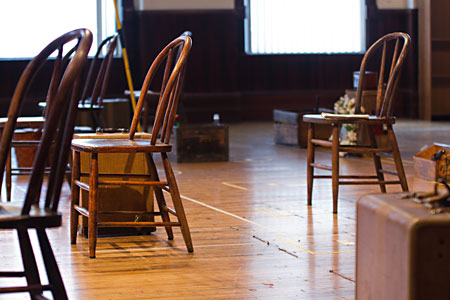 Scenic design for the play incorporates rearrangement of many chairs